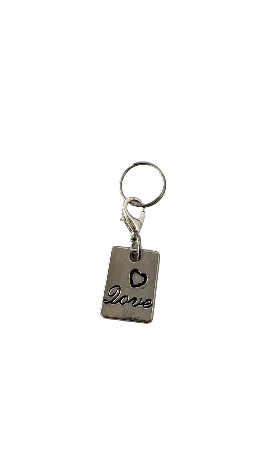 Silver charm with 'love' and heart charm on a white background