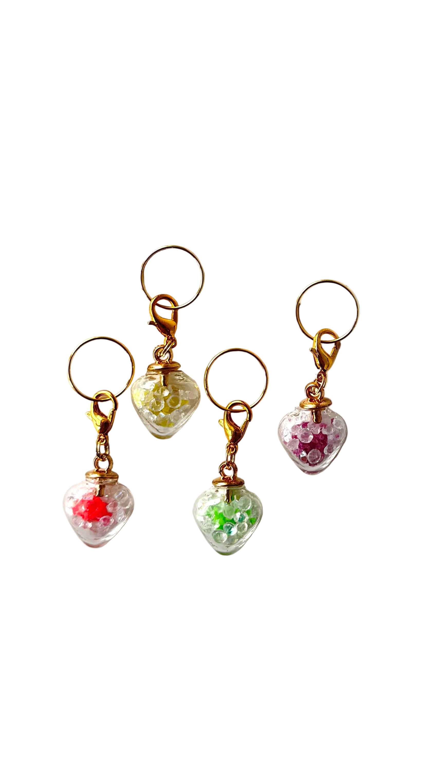 Set of four small decorative charms with colorful beads on a white background