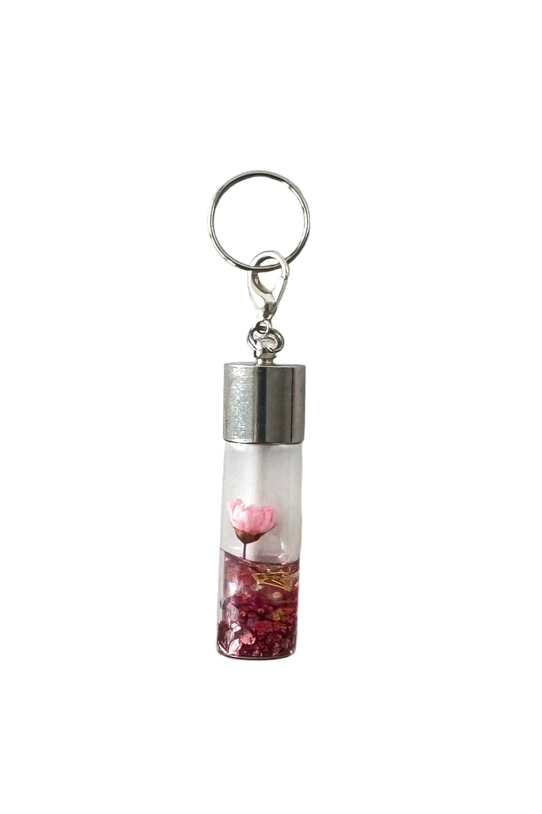 Charm with a clear tube containing pink heart-shaped objects on a white background