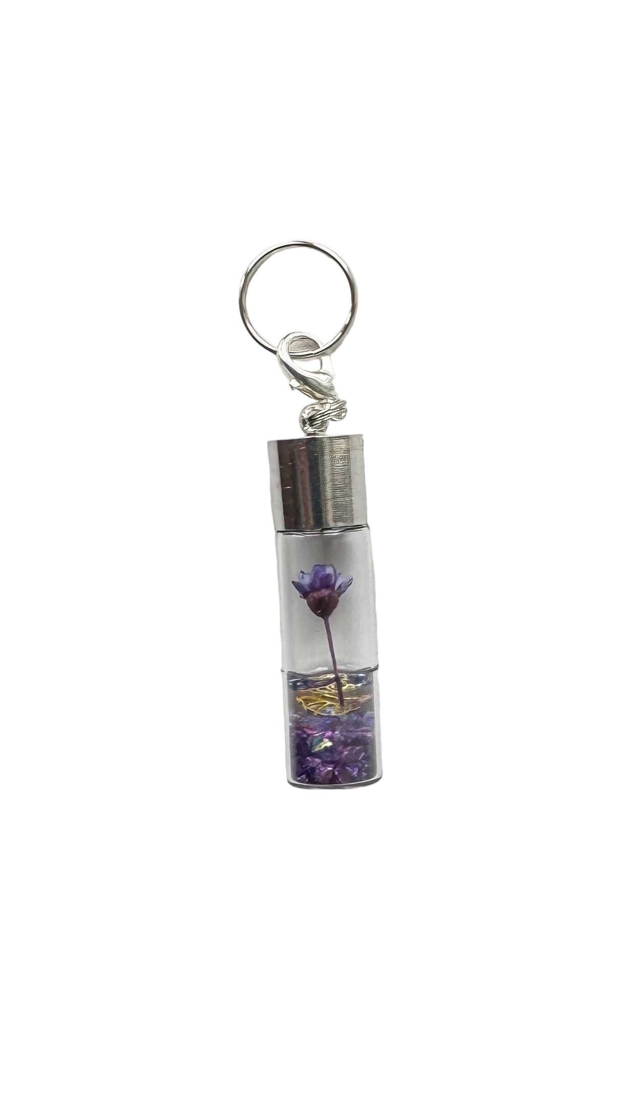 Charm with a small glass container holding a purple flower on a white background