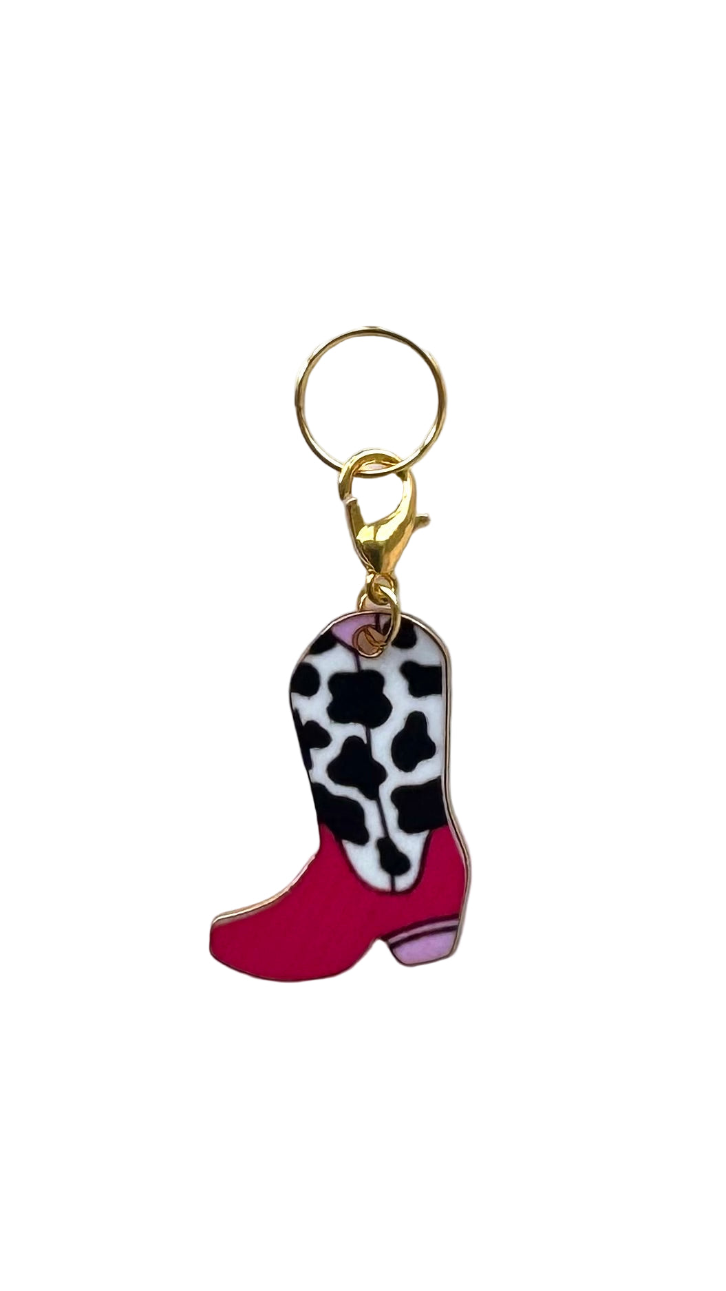 Cowboy boot charm with cow print and pink sole on a white background