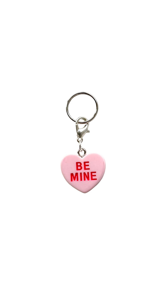 Heart-shaped charm with 'BE MINE' text on a white background