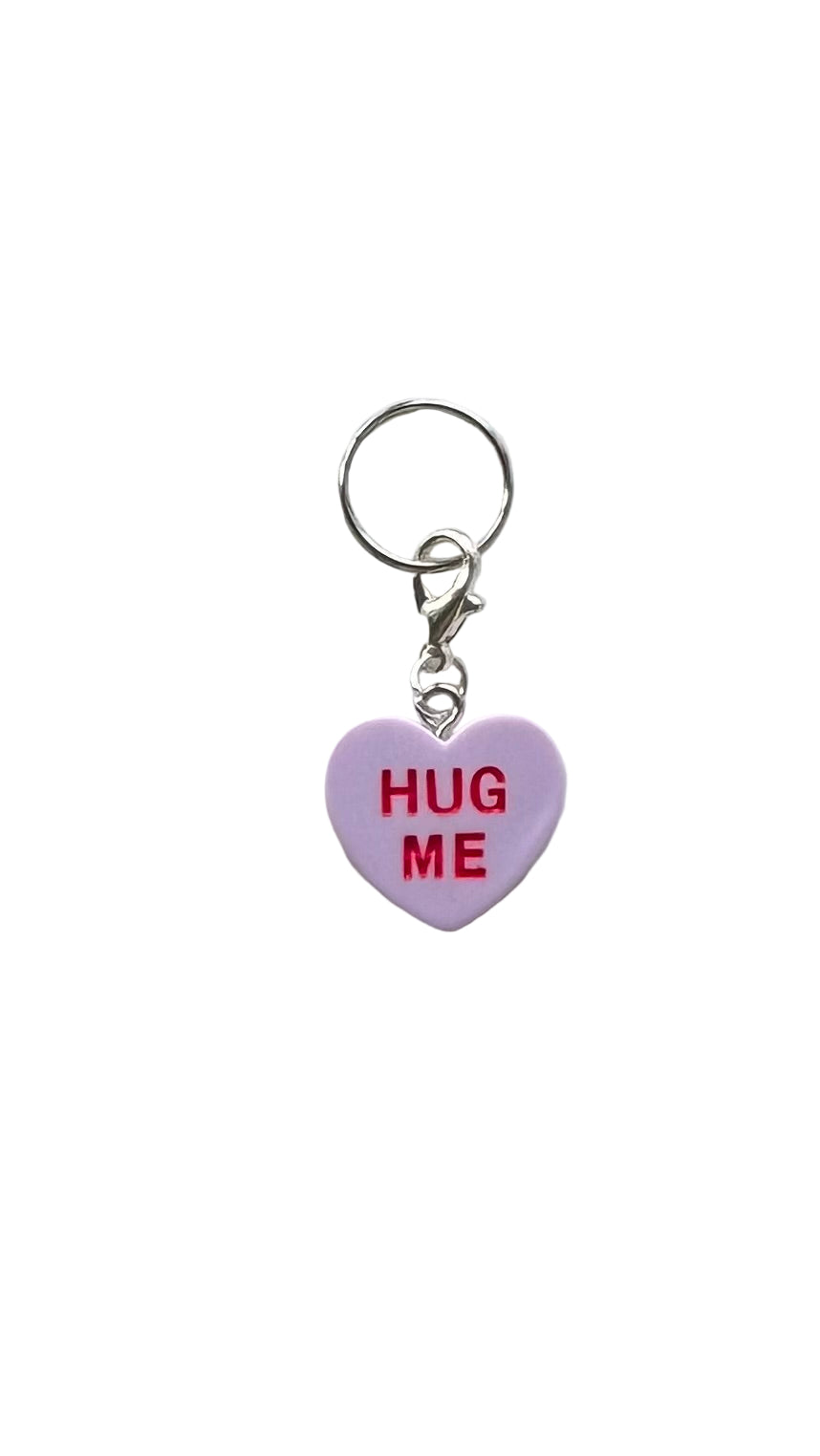 Heart-shaped charm with 'HUG ME' text on a white background
