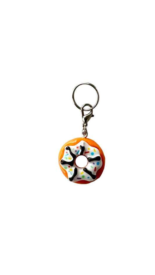 Donut-shaped charm with sprinkles on a white background