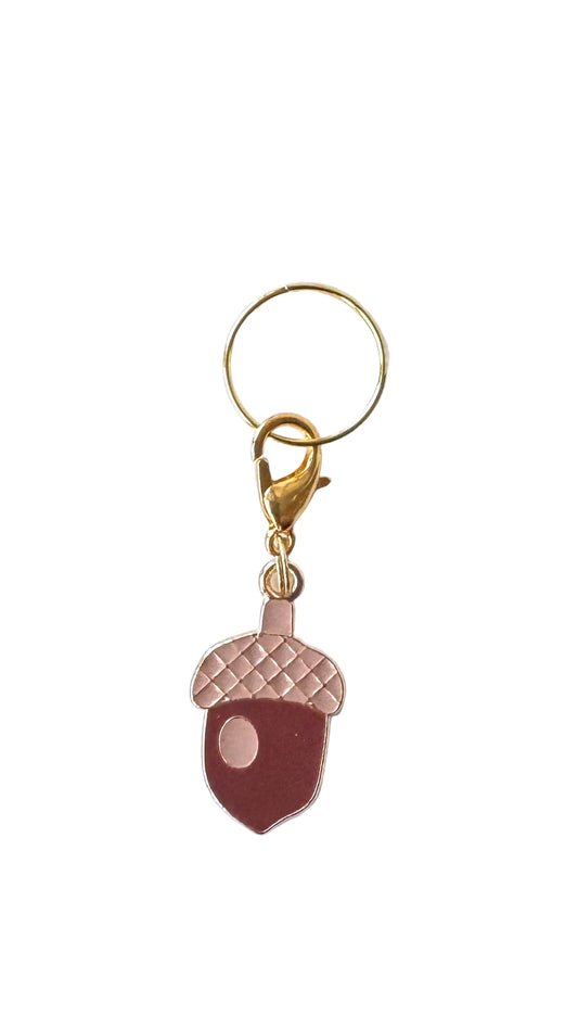 Charm with acorn design on a white background