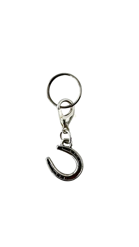 Metallic charm with horseshoe design on a white background