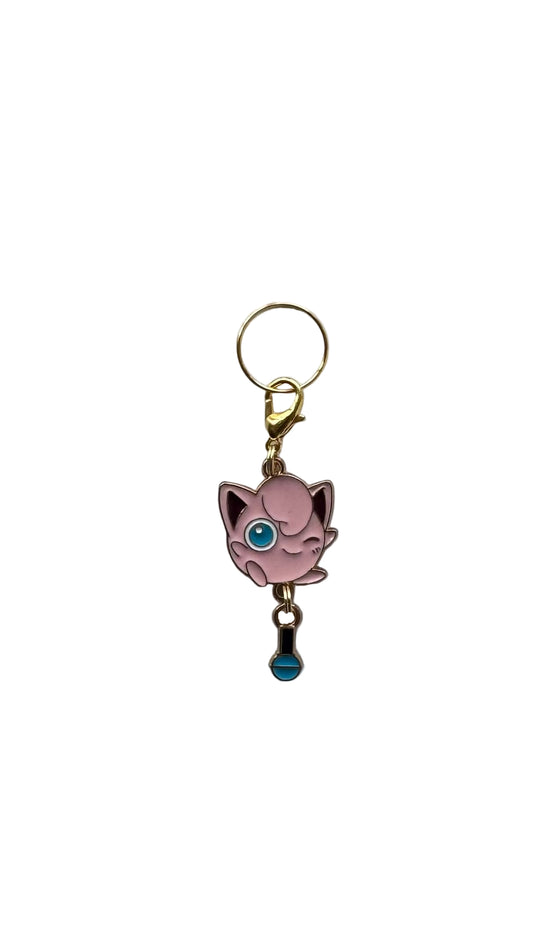 Pink cartoon character from pokemon charm with a blue gem on a white background