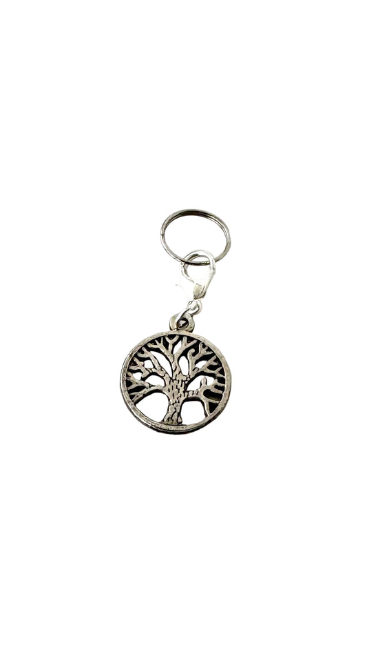 Silver charm with tree design on a white background