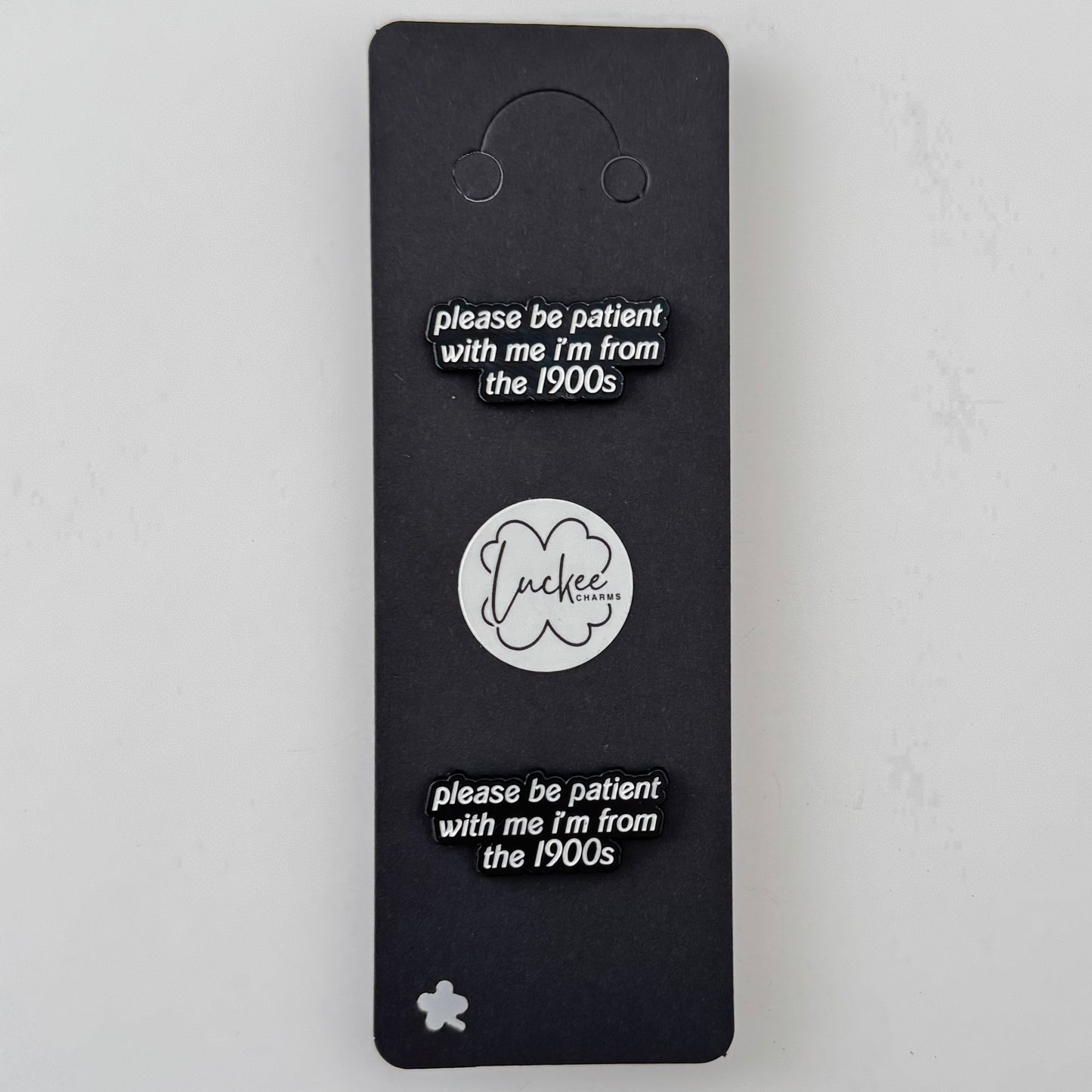 Black card with 'please be patient with me I'm from the 1900s' text and a logo on a white background