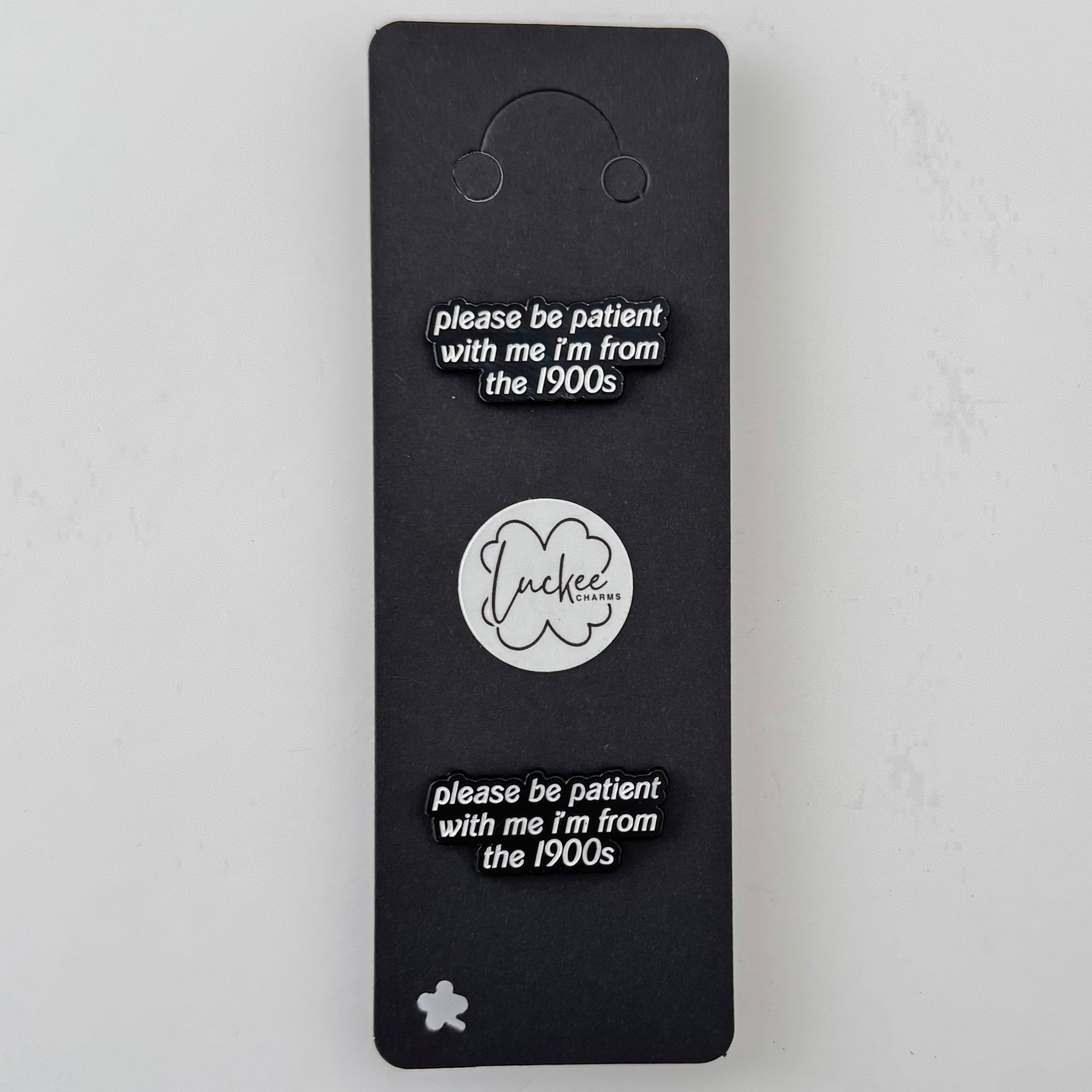 Black card with 'please be patient with me I'm from the 1900s' text and a logo on a white background