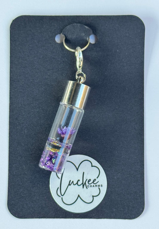 Charm with a clear container holding purple flowers on a black card with 'Lucky Charms' branding.
