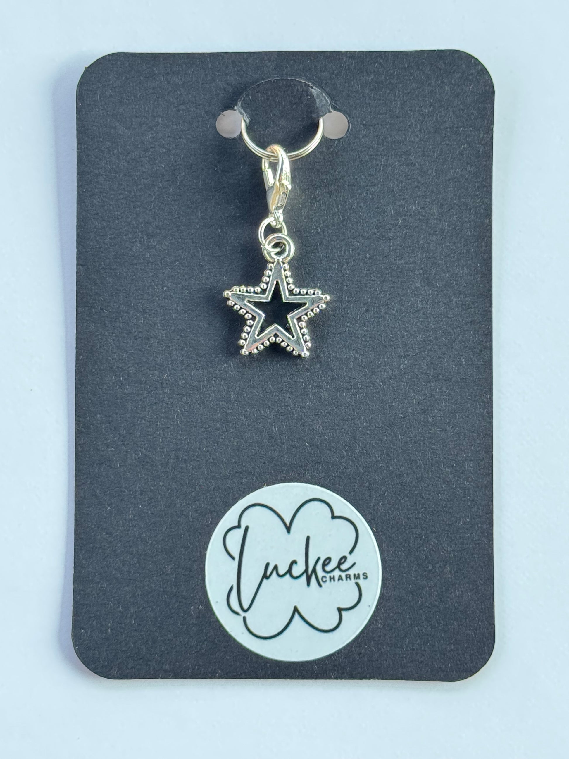 Star-shaped charm on a black card with a brand logo.