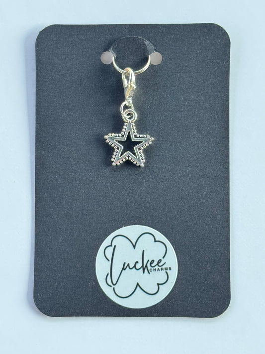 Star-shaped charm on a black card with a brand logo.