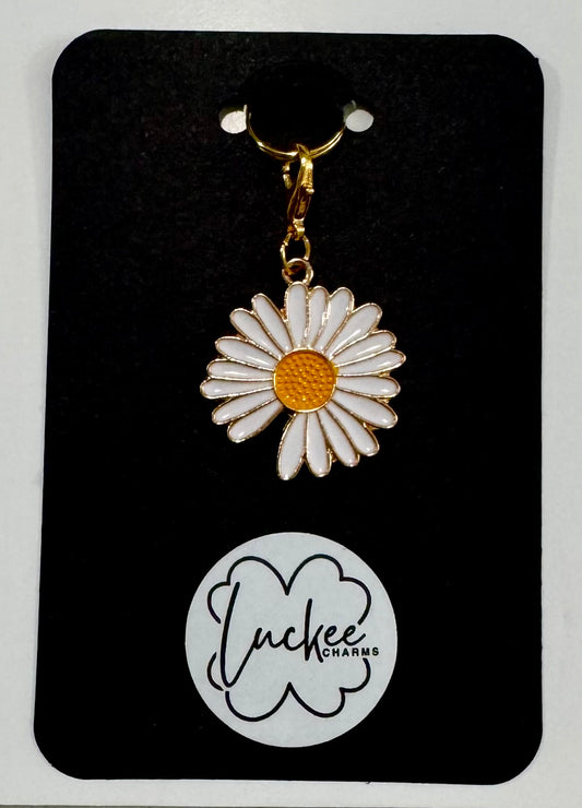 Daisy-shaped charm on a branded card.